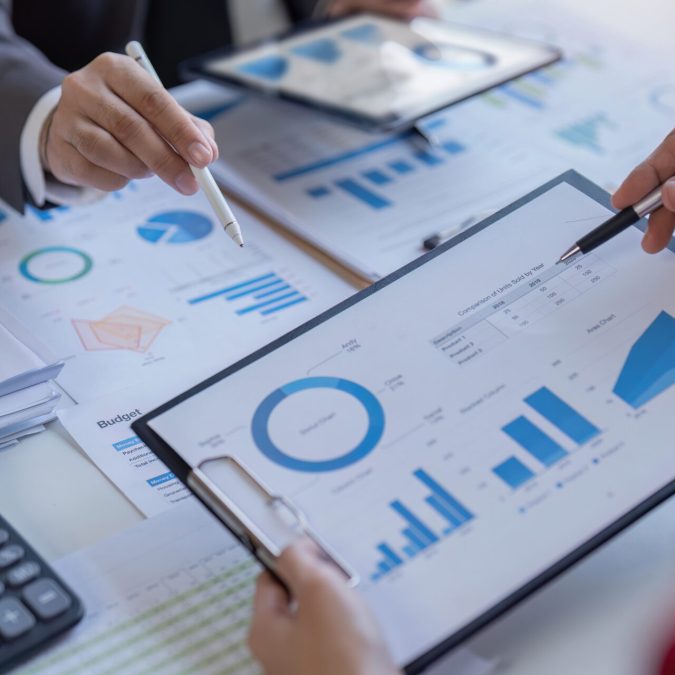 Bookkeeper team accountant or financial expert, economist accounting money with statistics graphs pointing on the accounts for investment results and income Company expenditure.